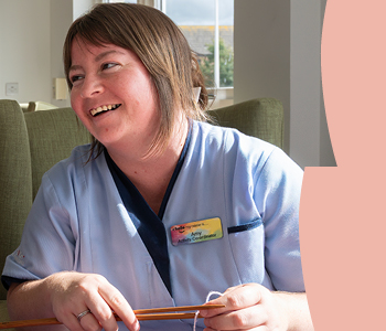 Woman smiling wearing a social care uniform