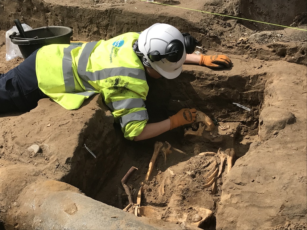 Image of an archaeologists examining human remains uncovered at South Leith Parish Church