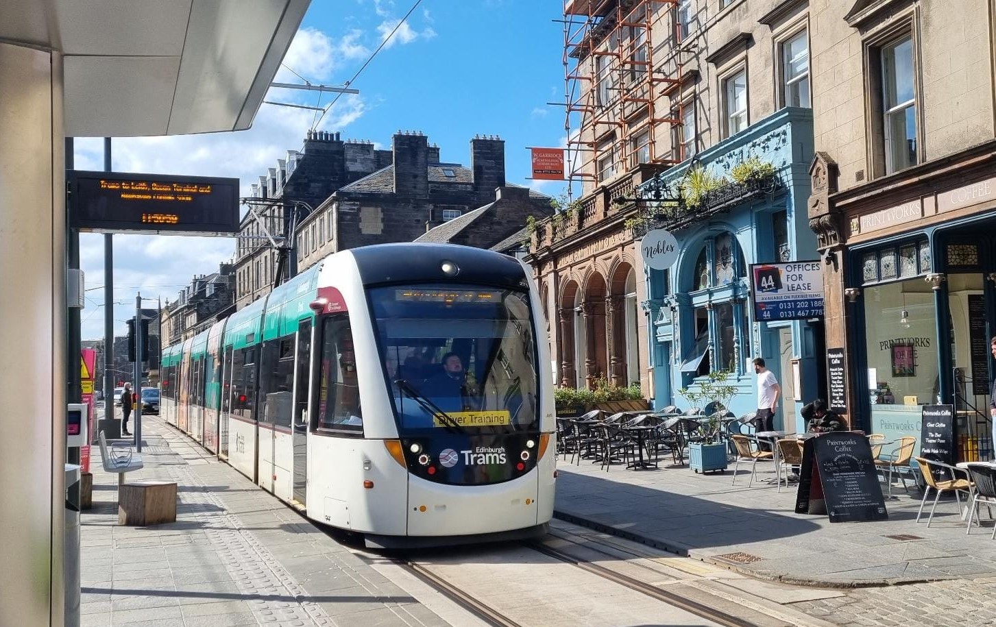 Photo of tram pulling into the Shore tram stop with businesses seen on the right