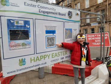 Child in front of Easter board. 